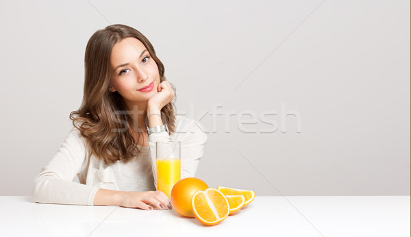 Young brunette woman having orange juice. Stock photo © lithian