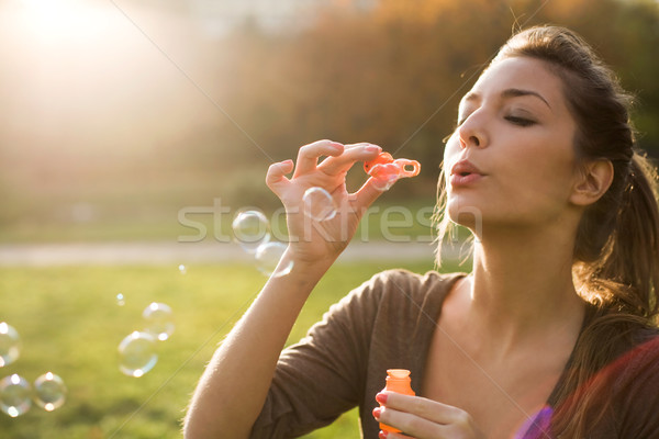 Stock photo: Blowing bubbles into the wind.