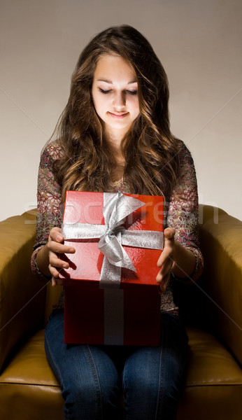 Beautiful brunette peeking inside gift box. Stock photo © lithian