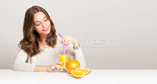 Young brunette woman having orange juice. Stock photo © lithian