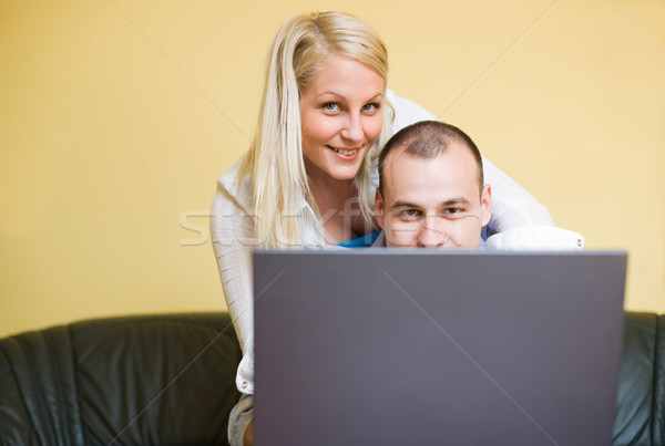 Young couple peeking over laptop screen Stock photo © lithian