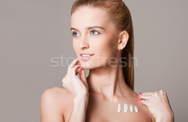 Blond woman using moisturizer. Stock photo © lithian