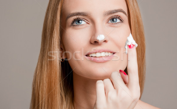 Blond woman using moisturizer. Stock photo © lithian