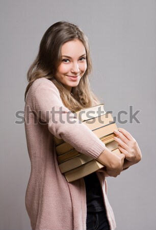 Young brunette with large pile of books. Stock photo © lithian