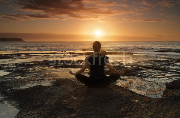 Meditativ yoga mare femeie şedinţei ocean Imagine de stoc © lovleah