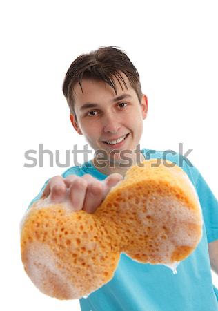 Teenager with outstretched hand holding a soapy sponge Stock photo © lovleah