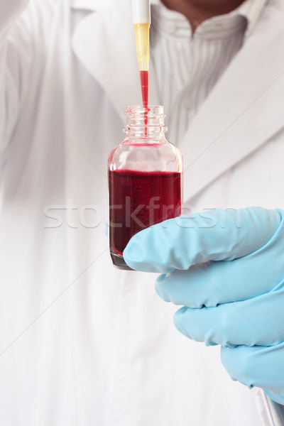Stock photo: Pipette aspirating liquid from bottle