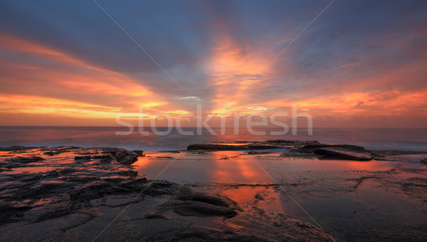 Streaks of orange red light at sunrise Curl Curl Stock photo © lovleah