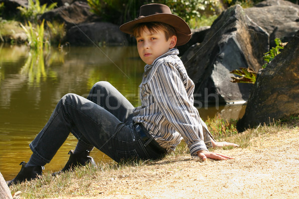 Rural boy sitting by banks of a river Stock photo © lovleah
