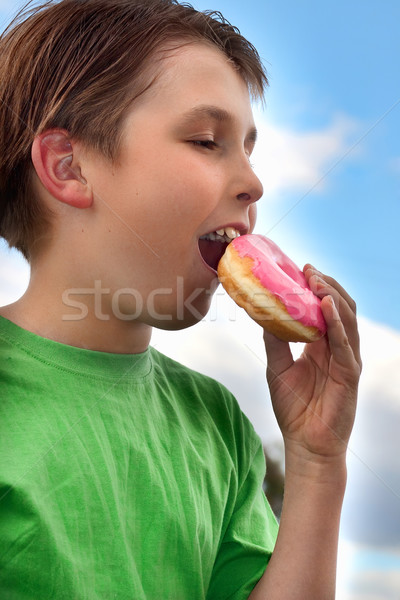Junge beißen rosa eisgekühlt Donut Stock foto © lovleah