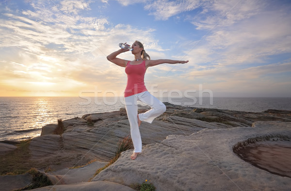 Woman balance drinking wqter during exercise Stock photo © lovleah