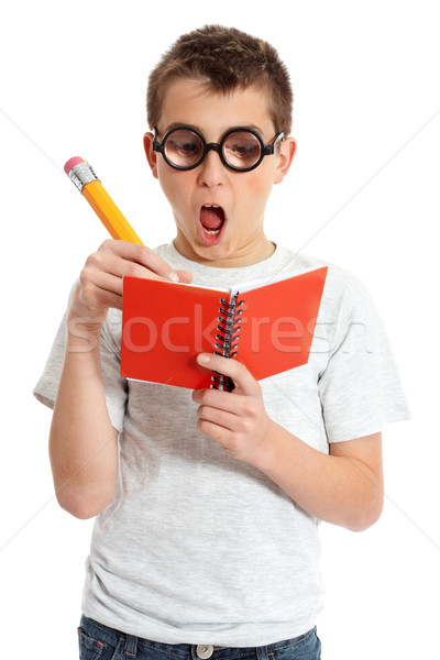 A comical boy student in geeky glasses writing in a book.   Stock photo © lovleah