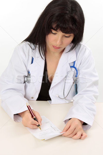 Female doctor writing a script for medicine Stock photo © lovleah