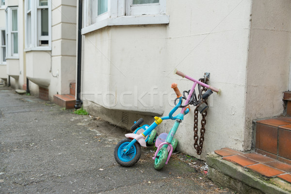 Two childrens scooters chained up in a street Stock photo © lucielang