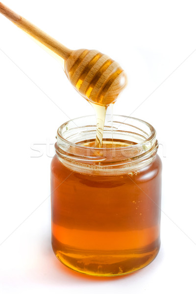 Honey dripping into jar over white Stock photo © lucielang