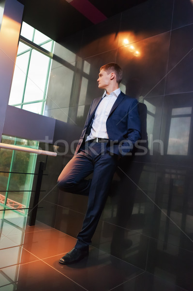 Young businessman resting on wall Stock photo © luckyraccoon