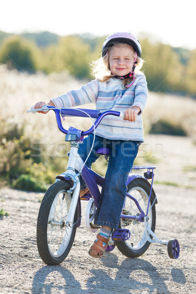Small funny kid riding bike with training wheels. Stock photo © luckyraccoon