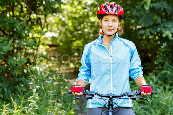 Portrait of happy young woman riding mountain bike. Stock photo © luckyraccoon