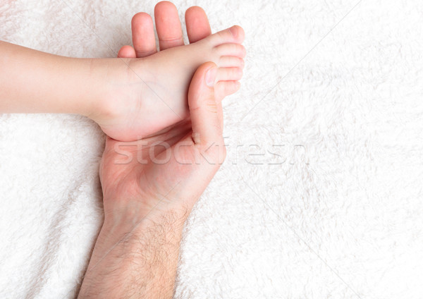 Stock photo: Father gently hold baby's leg