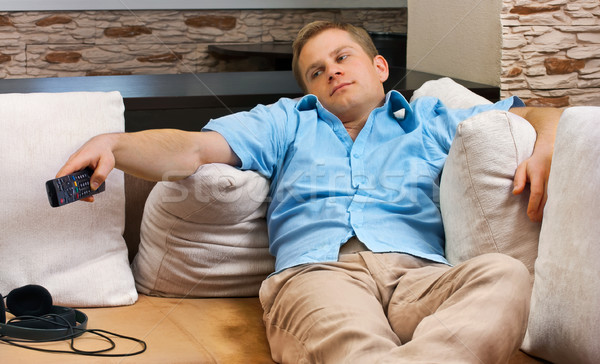 Man lying on sofa watching TV at home.  Stock photo © luckyraccoon