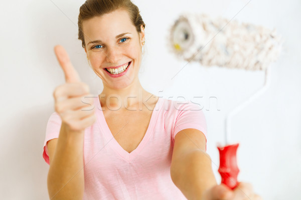Happy Woman showing thumb up with roller brush. Stock photo © luckyraccoon