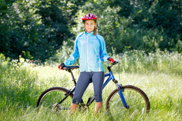 Portrait of happy young woman with mountain bike outdoors. Stock photo © luckyraccoon