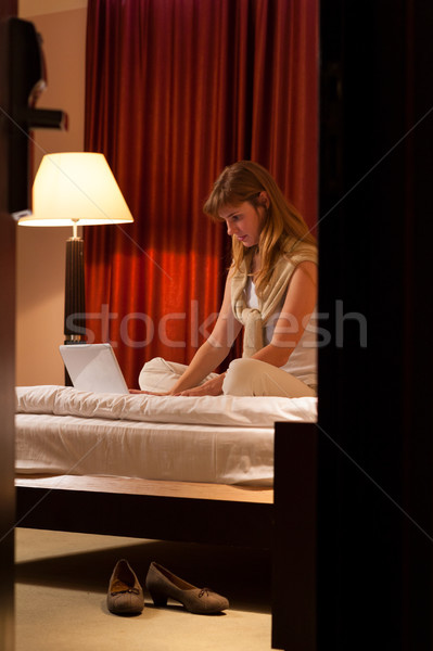 年輕女子 使用筆記本電腦 飯店 臥室 錢 因特網 商業照片 © luckyraccoon