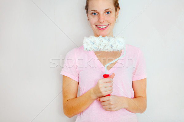 Happy Woman standing againtst wall with roller brush. Stock photo © luckyraccoon