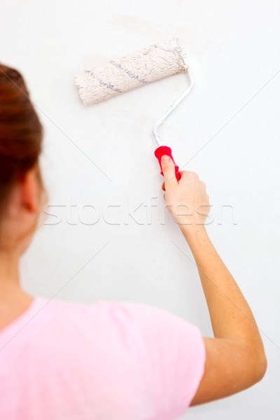 Young woman painting wall with roller brush. Stock photo © luckyraccoon