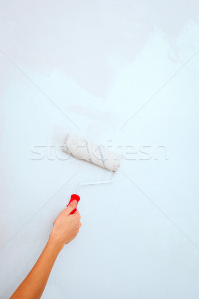 Hand with roller brush painting wall. Stock photo © luckyraccoon