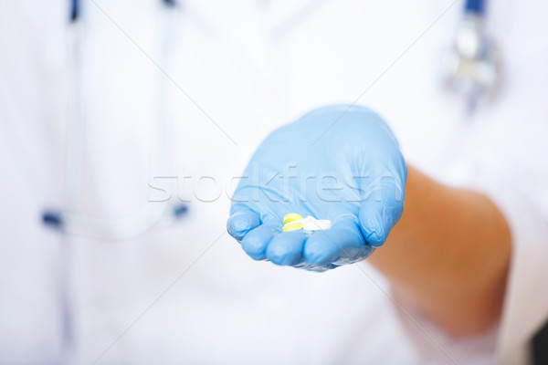 Ärzte Hand blau Handschuh halten heraus Stock foto © luckyraccoon