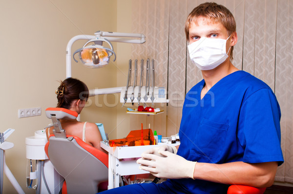 Stock photo: Young dentist in his office looking at the camera