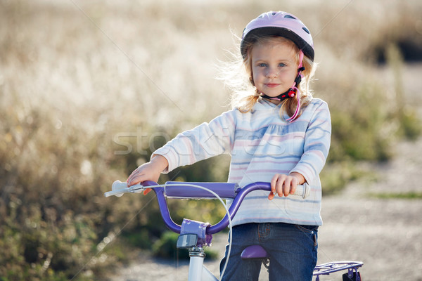 Small funny kid riding bike with training wheels. Stock photo © luckyraccoon