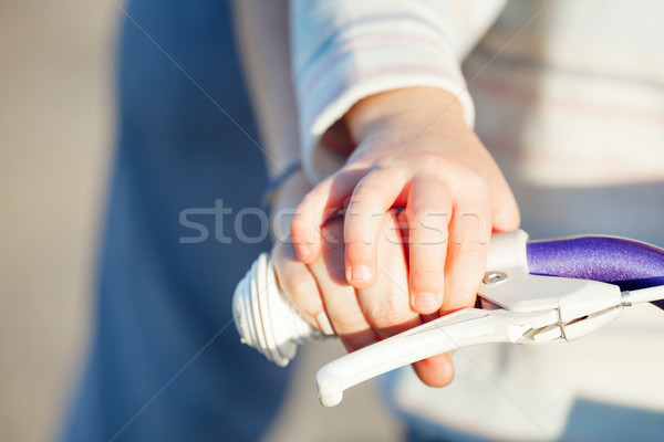 Child with parent learning riding bike - hands closeup. Stock photo © luckyraccoon