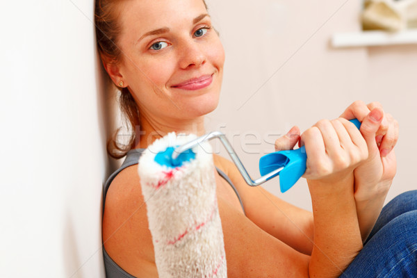 Happy woman with roller brush standing against wall. Stock photo © luckyraccoon