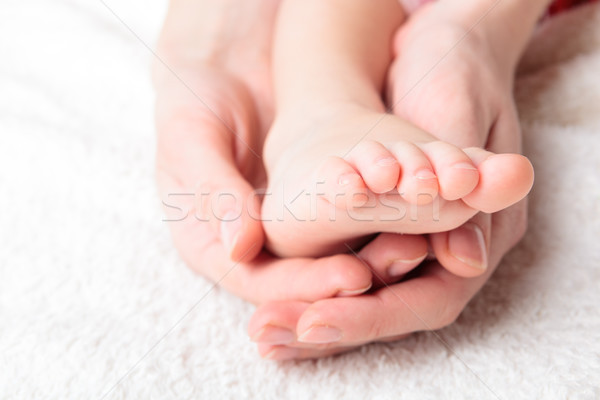 Stock photo: Mother gently hold baby's leg