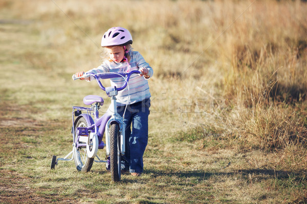 Small funny kid riding bike with training wheels. Stock photo © luckyraccoon