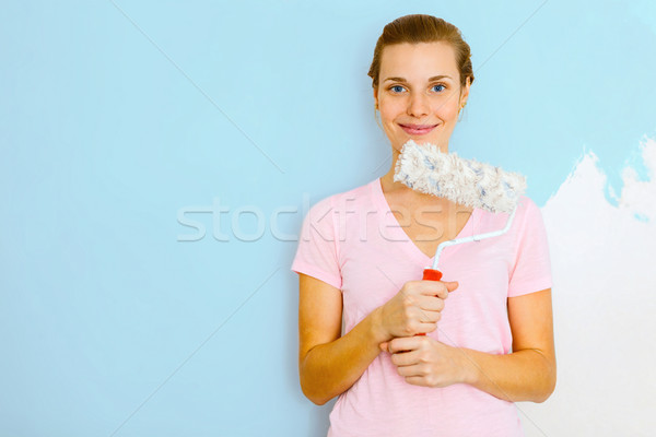 Happy Woman standing againtst wall with roller brush. Stock photo © luckyraccoon