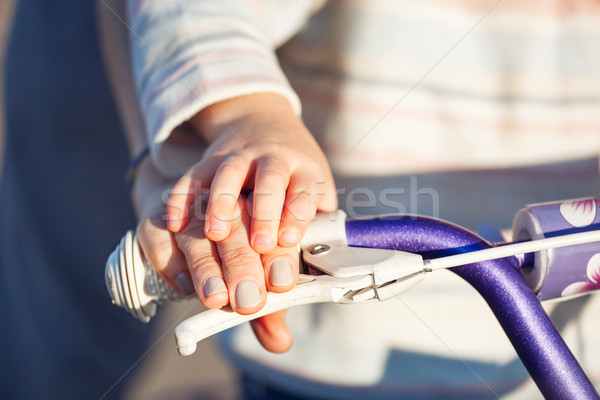 Child with parent learning riding bike - hands closeup. Stock photo © luckyraccoon