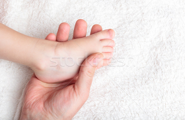 Father gently hold baby's leg Stock photo © luckyraccoon