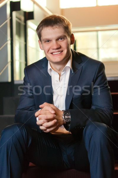 Young businessman sitting on stairs looking at camera Stock photo © luckyraccoon