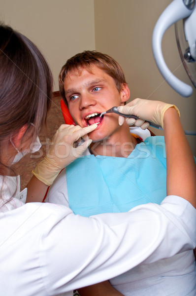 Jóvenes dentista tratamiento paciente oficina feliz Foto stock © luckyraccoon