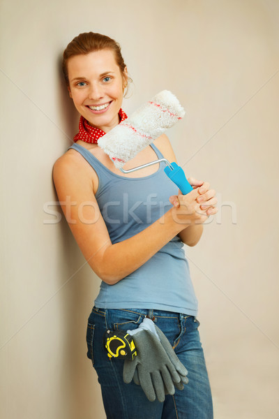 Happy woman with roller brush standing against wall. Stock photo © luckyraccoon