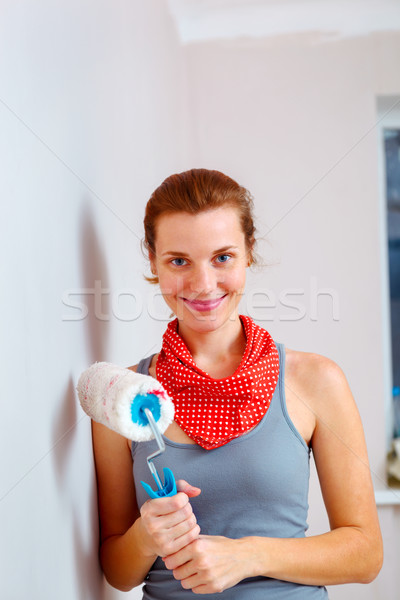 Happy woman with roller brush standing against wall. Stock photo © luckyraccoon