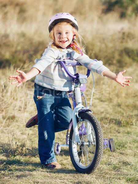 Small funny kid riding bike with training wheels. Stock photo © luckyraccoon