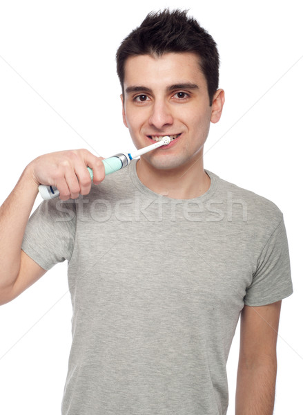 Fiatalember fogmosás jóképű elektromos fogkefe izolált Stock fotó © luissantos84