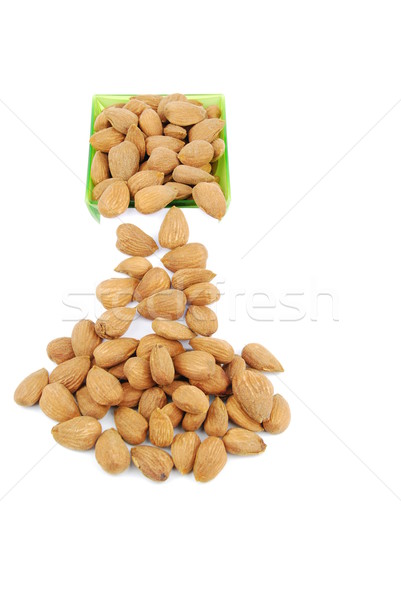 Scattered almond nuts on a cup sliding down Stock photo © luissantos84