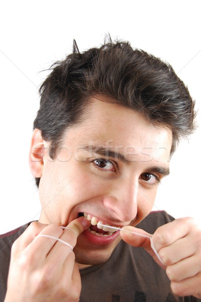 Stock photo: Man flossing his teeth