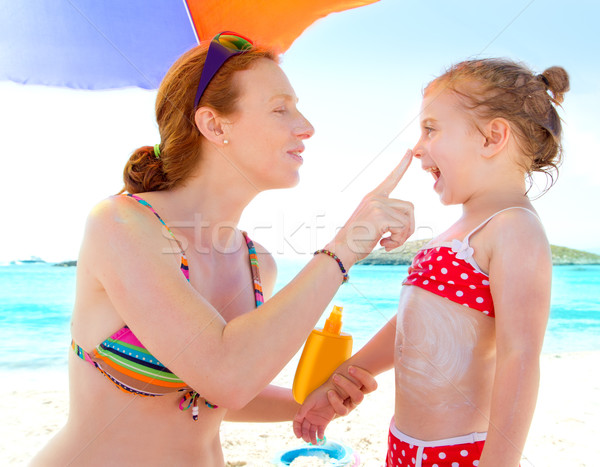 daughter and mother in beach with sunscreen Stock photo © lunamarina