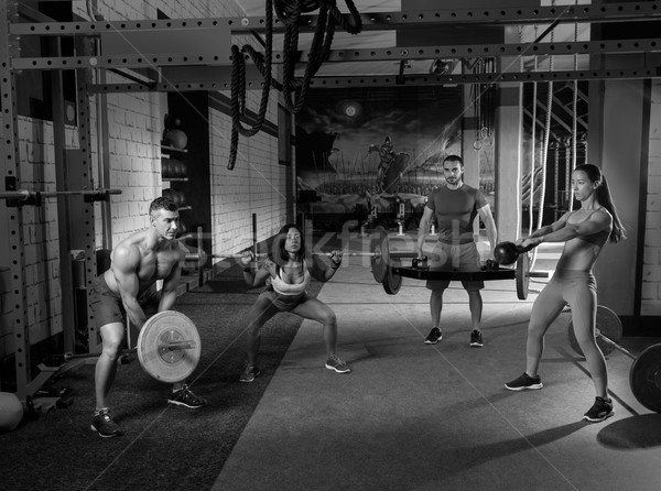 Gimnasio grupo levantamiento de pesas entrenamiento hombres ninas Foto stock © lunamarina